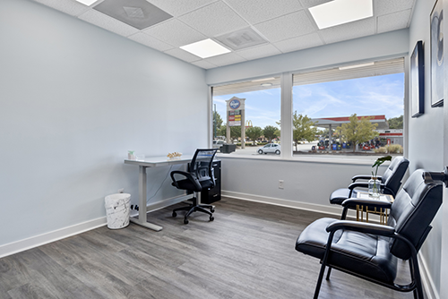 Front desk area of the Dalton clinic with black chairs and a large window looking out over the street.