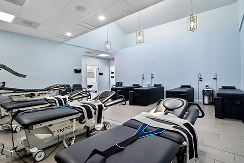 Treatment room at the Dalton clinic with Triton therapy tables and a blue colour scheme.