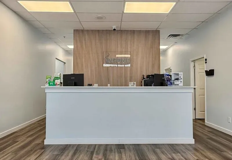 Reception desk at the Calhoun clinic, with a wood-panelled wall behind it and a check-in computer on the counter.