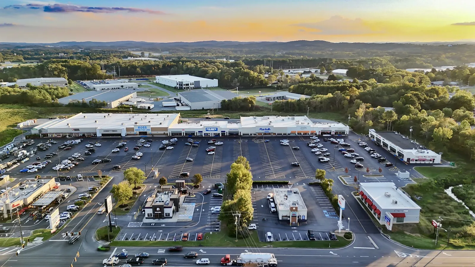 Aerial view of the Calhoun retail center and its parking lot at sunset.