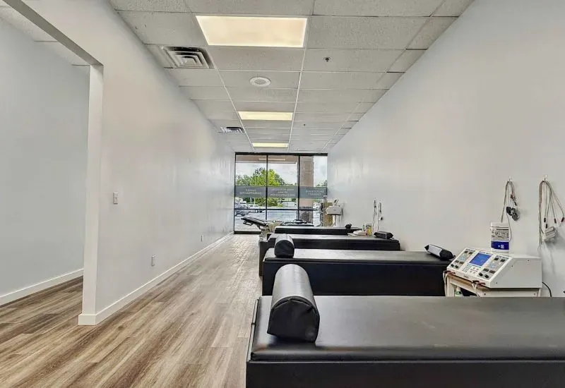 Open therapy room at the Calhoun clinic with treatment tables and therapy equipment along the wall.