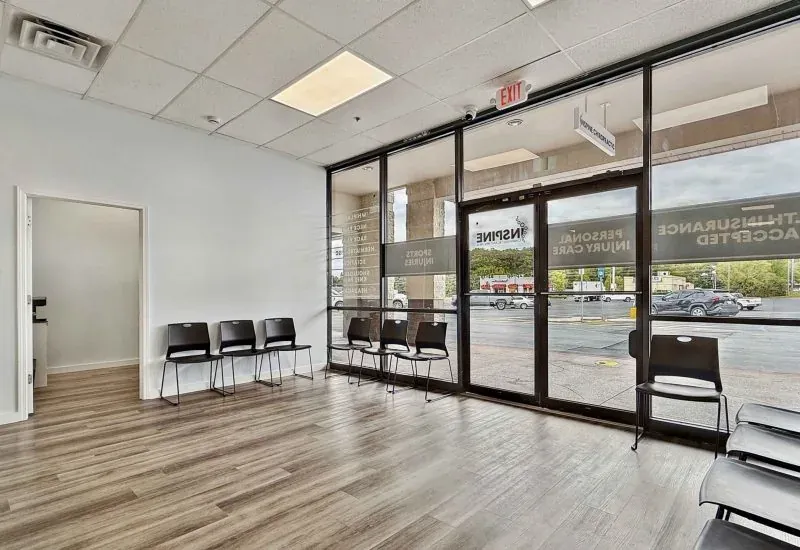 Waiting area at the Calhoun clinic, with a row of chairs along a glass storefront wall.
